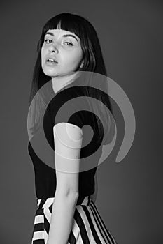 Studio portrait of a young woman against plain black background
