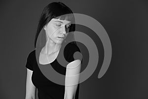 Studio portrait of a young woman against plain black background