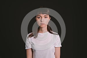 Studio portrait of a young woman against plain black background