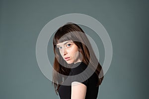 Studio portrait of a young woman against plain black background