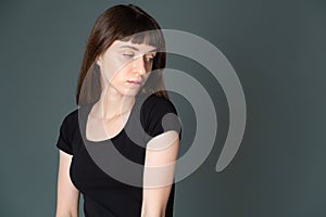 Studio portrait of a young woman against plain black background