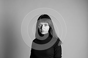 Studio portrait of a young woman against plain grey background