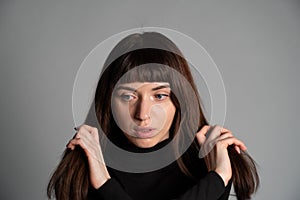 Studio portrait of a young woman against plain grey background