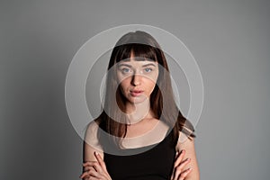 Studio portrait of a young woman against plain grey background