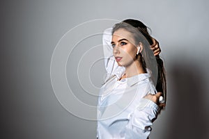 Studio portrait of young woman listening to music on wireless headphones. Smiling woman listening music in headphones