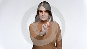 Studio portrait of young woman strictly saying no and shaking finger. Concept of ban, prohibition and taboo.