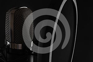 Studio professional microphone close-up on a black background for an inscription. Vocal and voice recording, work with sound