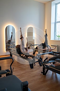 Studio reformer class dynamics, energetic group pilates reformer session with focused movement