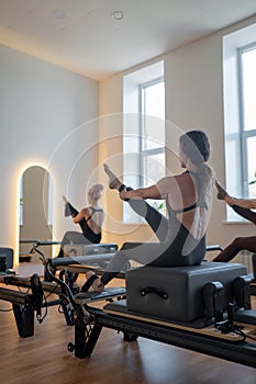 Studio reformer class dynamics, energetic group pilates reformer session with focused movement