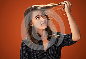 Studio, sad and woman with hair loss, confused and unhappy with hairdo, entangled and frustration. Red background