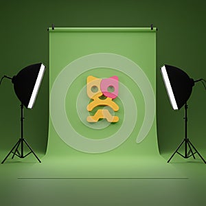 Studio setup with a green backdrop and two softbox lights on either side. A stylized