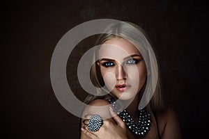 Studio shoot of blonde woman with jewelry. Fashion portrait.
