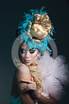 Studio shoot of woman with creative hairstyle, makeup and dress.