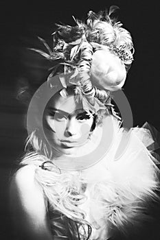 Studio shoot of woman with creative hairstyle, makeup and dress.