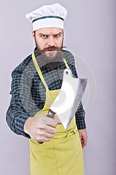 Studio shot of an angry bearded man holding a butcher knife