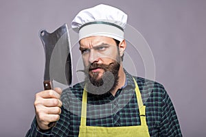 Studio shot of an angry bearded man holding a butcher knife