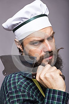 Studio shot of an angry bearded man holding a butcher knife