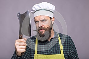 Studio shot of an angry bearded man holding a butcher knife