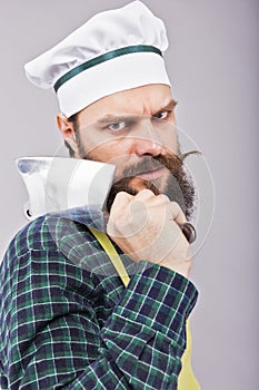 Studio shot of an angry bearded man holding a butcher knife