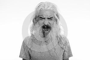 Studio shot of angry senior bearded man looking furious while shouting