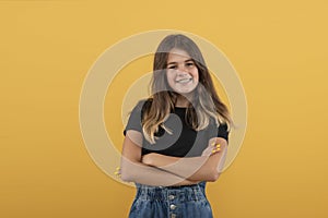 Studio shot of an attractive smiling teenager girl with braces with arms crossed