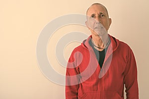 Studio shot of bald senior man against white background