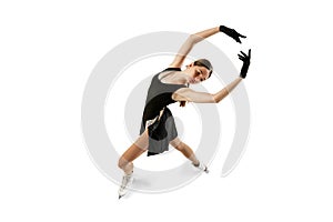 Studio shot of beautiful female figure skater in black festive stage dress practicing base elements of short program