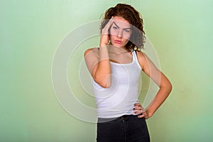 Studio shot of beautiful teenage girl looking stressed against g