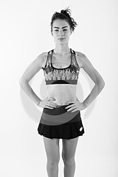 Studio shot of beautiful teenage girl standing while posing ready for sports and exercise against white background