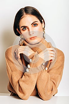 Studio shot of beautiful young woman with dark hair and blue eyes