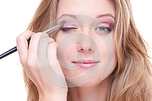 Studio shot of beautiful young woman doing make up