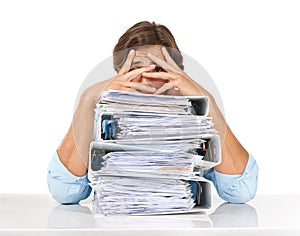 The paperwork just keeps piling up. Studio shot of a businessman sitting with a pile of files and looking demotivated