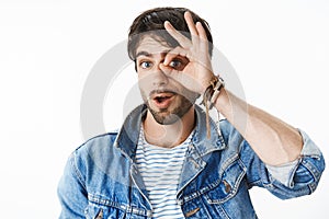 Studio shot of charismatic and joyful handsome european man with blue eyes showing zero or null with circle over eye and