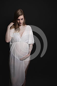 Studio shot of comfortable pregnant young woman