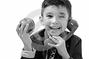Studio shot of cute happy boy smiling and holding green apple while talking on old telephone