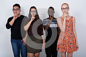 Studio shot of diverse group of multi ethnic friends with finger