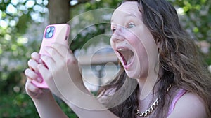 Studio shot of furious annoyed young woman with nose ring opening mouth widely, screaming, being mad, her mobile