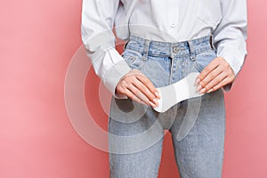 Studio shot of a girl holding a Pantyliner in her hand, for menstruation. The concept of feminine hygiene.