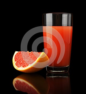 Studio shot of grapefruit juice and quarter isolated on black