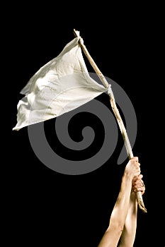 Studio shot of hands holding up a white flag isolated on black