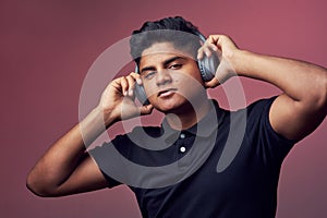 I like a good beat. Studio shot of a handsome young man wearing headphones.