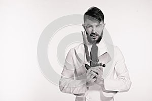 Studio shot of a happy bearded young chef holding sharp knives over white background. Chef with knife. Handsome angry serious chee