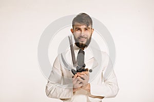 Studio shot of a happy bearded young chef holding sharp knives over white background. Chef with knife. Handsome smiling cheef hold