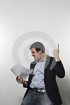 Studio shot of happy businessman celebrating a paper