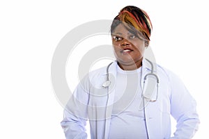 Studio shot of happy fat black African woman doctor smiling whil