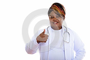 Studio shot of happy fat black African woman doctor smiling whil