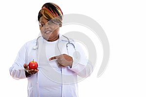 Studio shot of happy fat black African woman doctor smiling whil