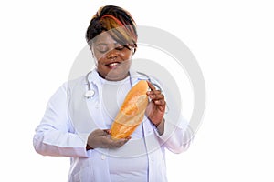 Studio shot of happy fat black African woman doctor smiling whil