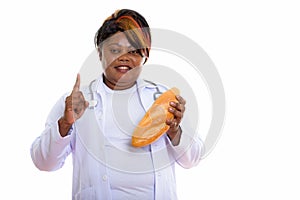 Studio shot of happy fat black African woman doctor smiling whil