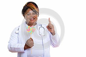 Studio shot of happy fat black African woman doctor smiling whil